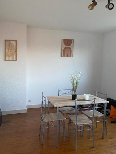 une table de salle à manger et des chaises dans une pièce dans l'établissement Appartement Cosy vue sur la cathédrale Albi, à Albi