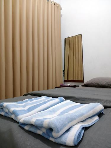 a bedroom with two beds and a mirror at Moshi Moshi in Probolinggo
