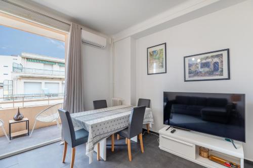 une salle à manger avec une table et une grande fenêtre dans l'établissement L'ESTEREL Au pied de la méditerranée 6 couchages, à Juan-les-Pins