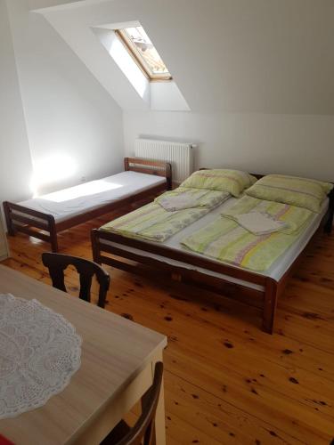 two beds in a room with a table and chairs at Pokój 4osobowy in Swornegacie