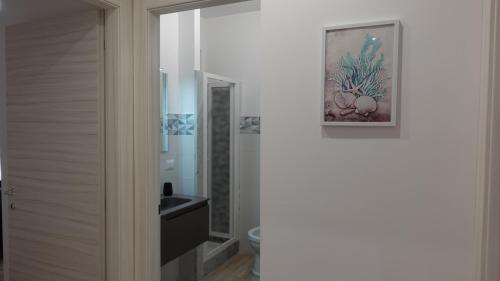 łazienka z toaletą i obrazem na ścianie w obiekcie Stella di Mare w mieście Balestrate