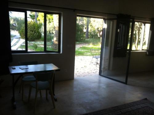 Zimmer mit einem Tisch und Stühlen sowie einer Glasschiebetür in der Unterkunft Du Coté de Chez Soi in La Ciotat