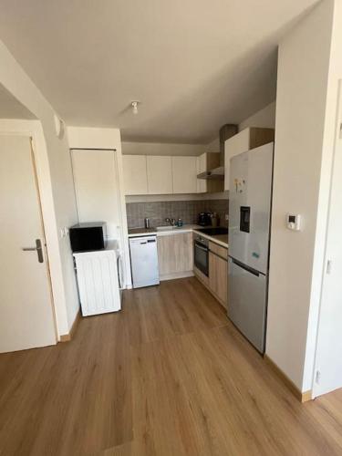 une grande cuisine avec des appareils blancs et du parquet dans l'établissement Appartement avec piscine, à Saint-Laurent-du-Var