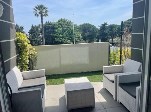 two chairs and a table on a patio at Appartement avec piscine in Saint-Laurent-du-Var