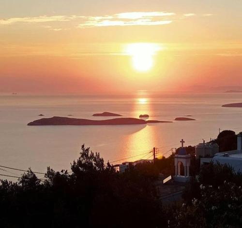 a sunset over a body of water with an island at Efi's apartment in Apróvaton