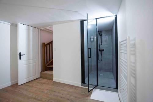 une salle de bain avec une douche en verre dans une chambre dans l'établissement DUPLEX AU COEUR DU 16 Eme, à Paris