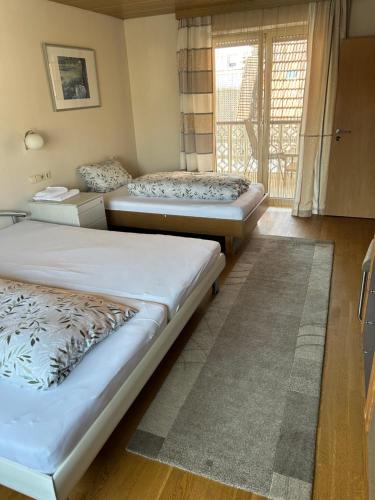 three beds in a room with a window at Apartment am Rathaus in Rödermark