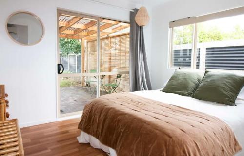 a bedroom with a bed and a large window at Cute one bedroom near Waterview in Auckland