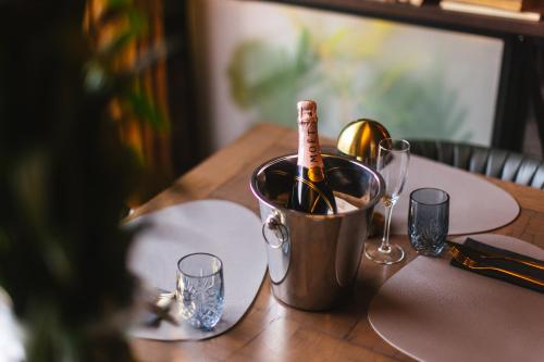 a bottle of champagne in a bucket on a table at Hotel - Pansion Kod Ruže - Strossmayer No 1 - breakfast included in Osijek