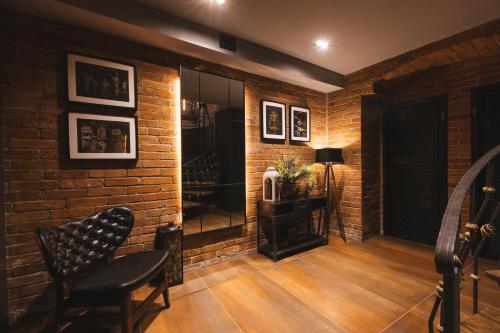 a room with a brick wall and a chair and a mirror at Hotel - Pansion Kod Ruže - Strossmayer No 1 - breakfast included in Osijek