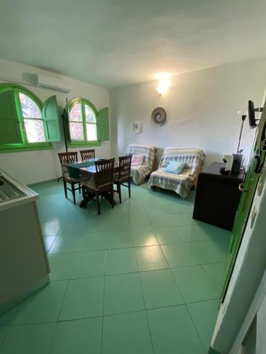 a living room with a table and a couch at Castelletto Verde in Bari Sardo