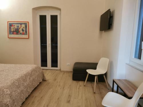 a bedroom with a bed and a chair and a table at Kikka's House in La Spezia