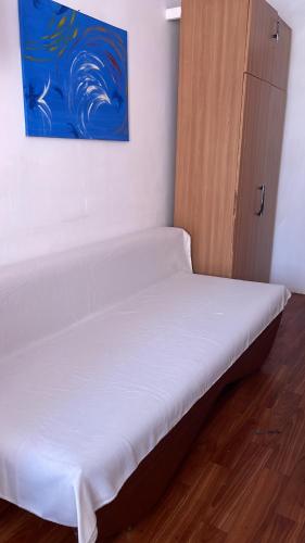 a bed in a room with a painting on the wall at Garsonieră micuță în Constanța in Constanţa