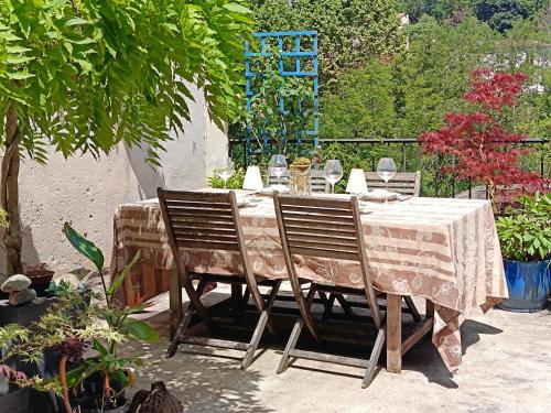 a table with two chairs and a table cloth at Les chambres des artistes in Laguépie