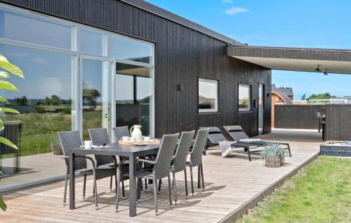 a patio with a table and chairs on a deck at Cozy Home In Børkop With Sauna in Børkop