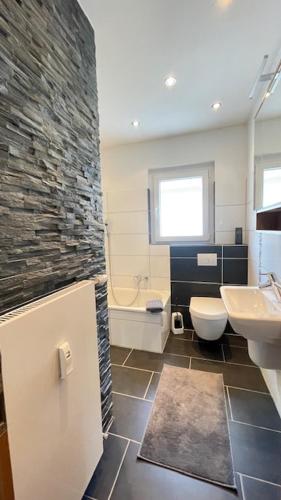 Un baño con lavabo, inodoro y bañera. en LeoMi Ferienwohnung, en Hagen