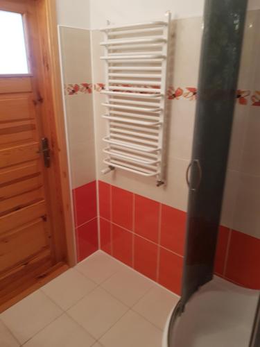 a bathroom with a toilet and red and white tiles at Pokój 2osobowy in Swornegacie