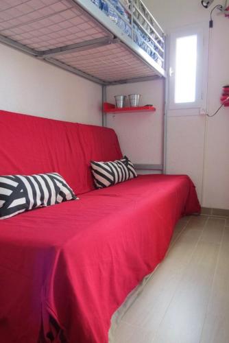 - un lit rouge avec deux oreillers dans l'établissement Superbe Studio Cabine Face Marina- résidence Piscine - 2 ou 3 personnes - 4PV47E, au Barcarès