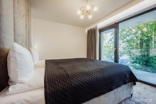 a bedroom with a bed and a large window at Cristal in Ustka