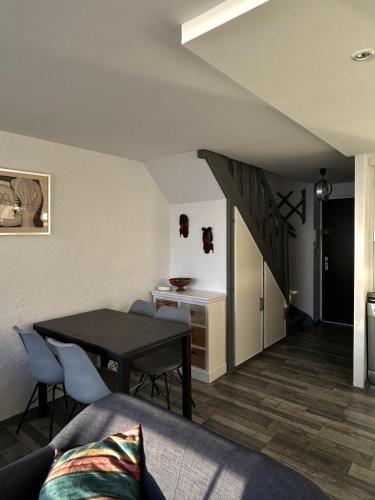 un salon avec une table et des chaises et un escalier dans l'établissement les cles de la mer, à Wimereux