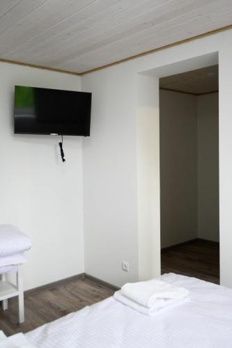 a bedroom with a bed with a flat screen tv on the wall at Готельно-ресторанний комплекс Традиція in Pistyn