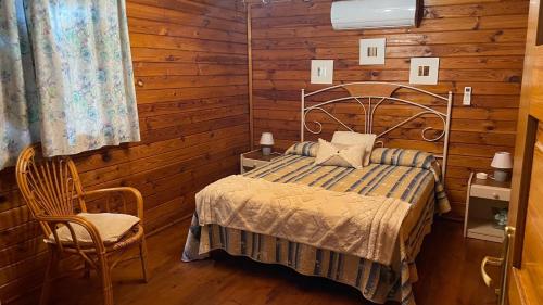 a bedroom with a bed and a wooden wall at Casas Rurales Tabla Honda in El Robledo
