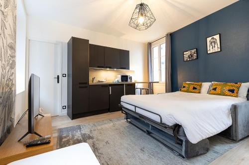 une chambre avec un grand lit et une cuisine dans l'établissement Smart Inn Fontainebleau Centre- Studio, à Fontainebleau