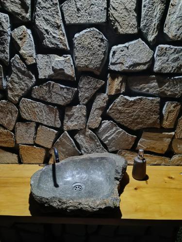 a stone sink in front of a stone wall at ILIS House Matka in Skopje