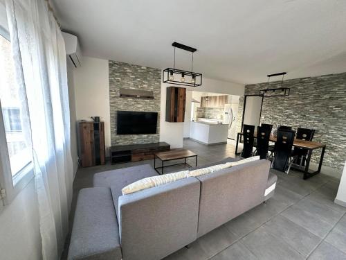 Il comprend un salon doté d'un canapé et d'une télévision. dans l'établissement Maison avec piscine privé eyguieres, à Eyguières