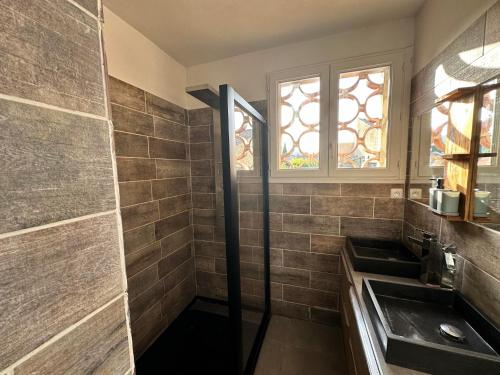 une salle de bain avec un lavabo et une fenêtre dans l'établissement Maison avec piscine privé eyguieres, à Eyguières