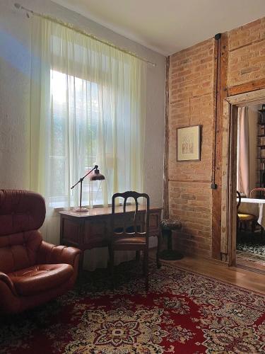 a living room with a desk and a chair and a window at Romantic getaway apartment in Rakvere