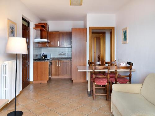 a kitchen and living room with a table and chairs at Residence Besass, GTSGroup in Tignale