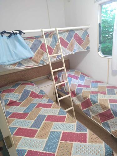 une chambre avec deux lits superposés dans une pièce dans l'établissement mobil-home, à Bassignac