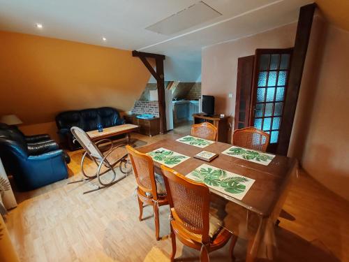 un salon avec une table et des chaises en bois dans l'établissement Beaux prés 68, à Colmar