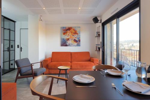 un salon avec un canapé et une table dans l'établissement Aix Rooftop Appartement Luxe T2 - hypercentre Rotonde - Terrasse - Vue - Parking, à Aix-en-Provence