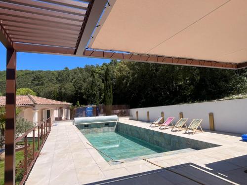 - une piscine avec 2 chaises longues et une piscine dans l'établissement Maison piscine et SPA, à Saint-Martin-de-Valgalgues