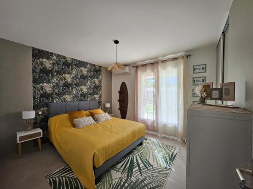 une chambre avec un lit avec une couverture jaune dans l'établissement Maison piscine et SPA, à Saint-Martin-de-Valgalgues