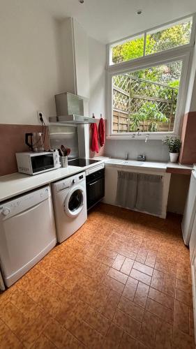 une cuisine avec une machine à laver et une fenêtre dans l'établissement Appartement - Cannes proche Croisette avec jardin, à Cannes