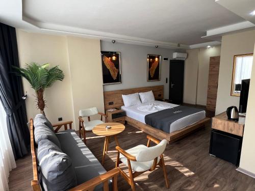 a bedroom with a bed and a couch and a table at coci butik hotel in Mezitli