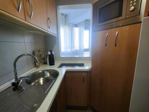 mała kuchnia ze zlewem i oknem w obiekcie Bajondillo Torremolinos Vistas al mar con piscina w mieście Torremolinos