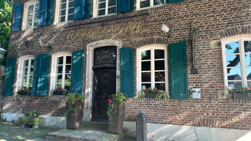 a brick building with green shutters and a door at Apartment Savanna im historischen Stadtkern Linn in Krefeld, nähe Düsseldorf Messe, Airport, Parkmöglichkeiten direkt vor dem Haus in Krefeld