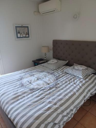 - un lit avec une couette à rayures bleue et blanche dans l'établissement Mer et calme, au Cannet