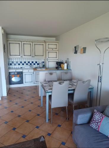 une cuisine avec une table, des chaises et un canapé dans l'établissement Mer et calme, au Cannet