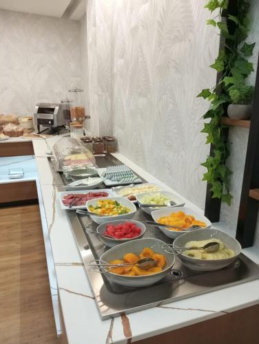 a kitchen counter with many bowls of food on it at Hotel Lara in Valença