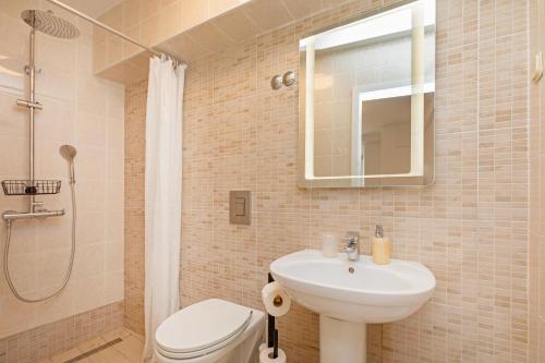 a bathroom with a sink and a toilet and a shower at SoHo apartment on the waterfront in Mlini