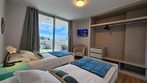 a hotel room with two beds and a window at Magnólia Residence in Funchal