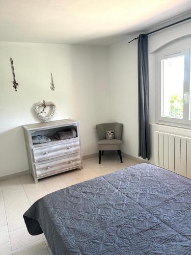 une chambre avec un lit, une chaise et une fenêtre dans l'établissement Appartement Calme entre mer, montagne et rivière, à Conca