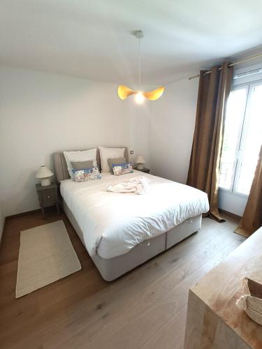 une chambre avec un lit blanc et une fenêtre dans l'établissement Disney T3 LUXE neuf 6P 2 ch 2 salle de bain parking privé en sous sol lit bébé C105, à Chessy