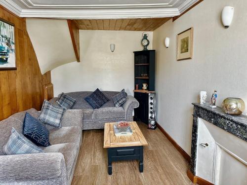 un salon avec un canapé et une table dans l'établissement Charmante maison à la campagne, à Rânes