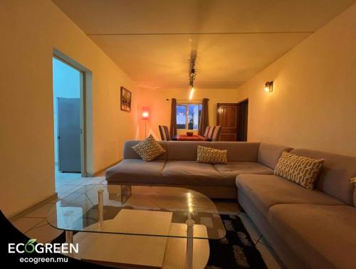 a living room with a couch and a glass table at Sapphire 202 TWO ROOM APARTMENT in Ebene